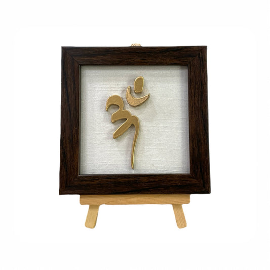 Vastu Aum 
 Symbol in Metal on white silk backdrop with a display stand.