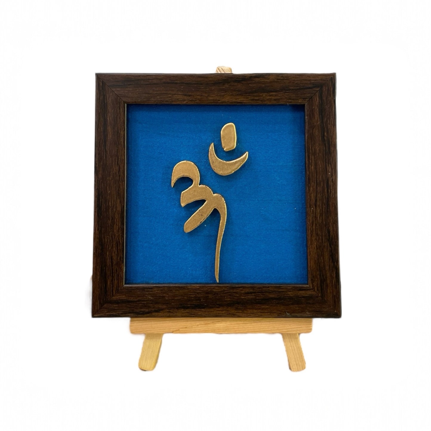 Vastu Aum
Symbol in Metal on blue silk backdrop with a display stand.