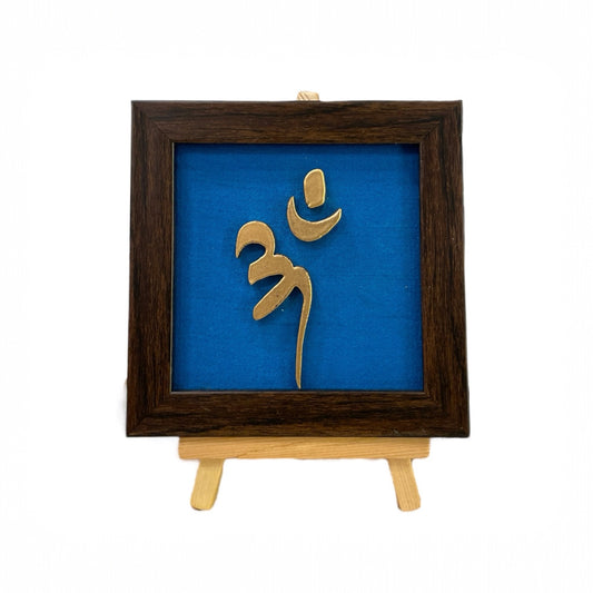 Vastu Aum 
Symbol in Metal on blue silk backdrop with a display stand.