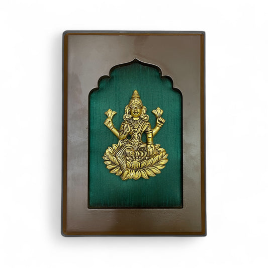 brass lakshmi with green silk backdrop.
