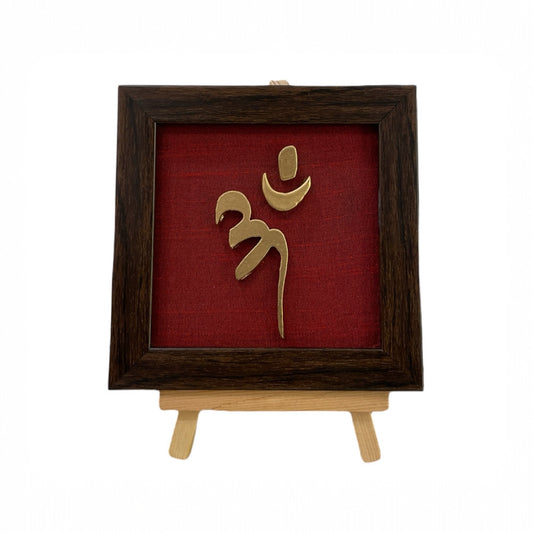 Vastu Aum 
Symbol in Metal on Wine red silk backdrop.