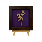 Vastu Aum 
 Symbol in Metal on Purple silk backdrop.
