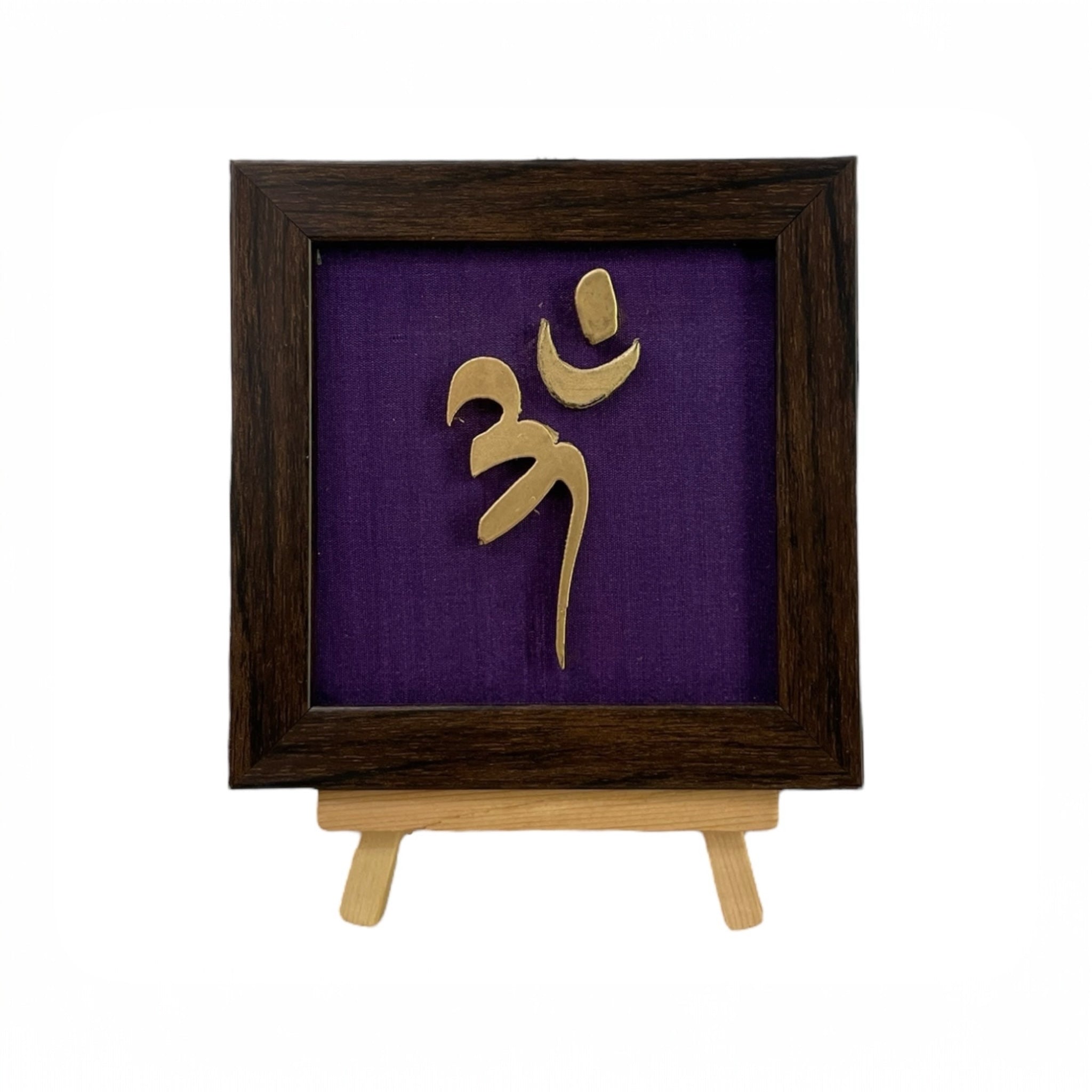 Vastu Aum 
 Symbol in Metal on Purple silk backdrop.