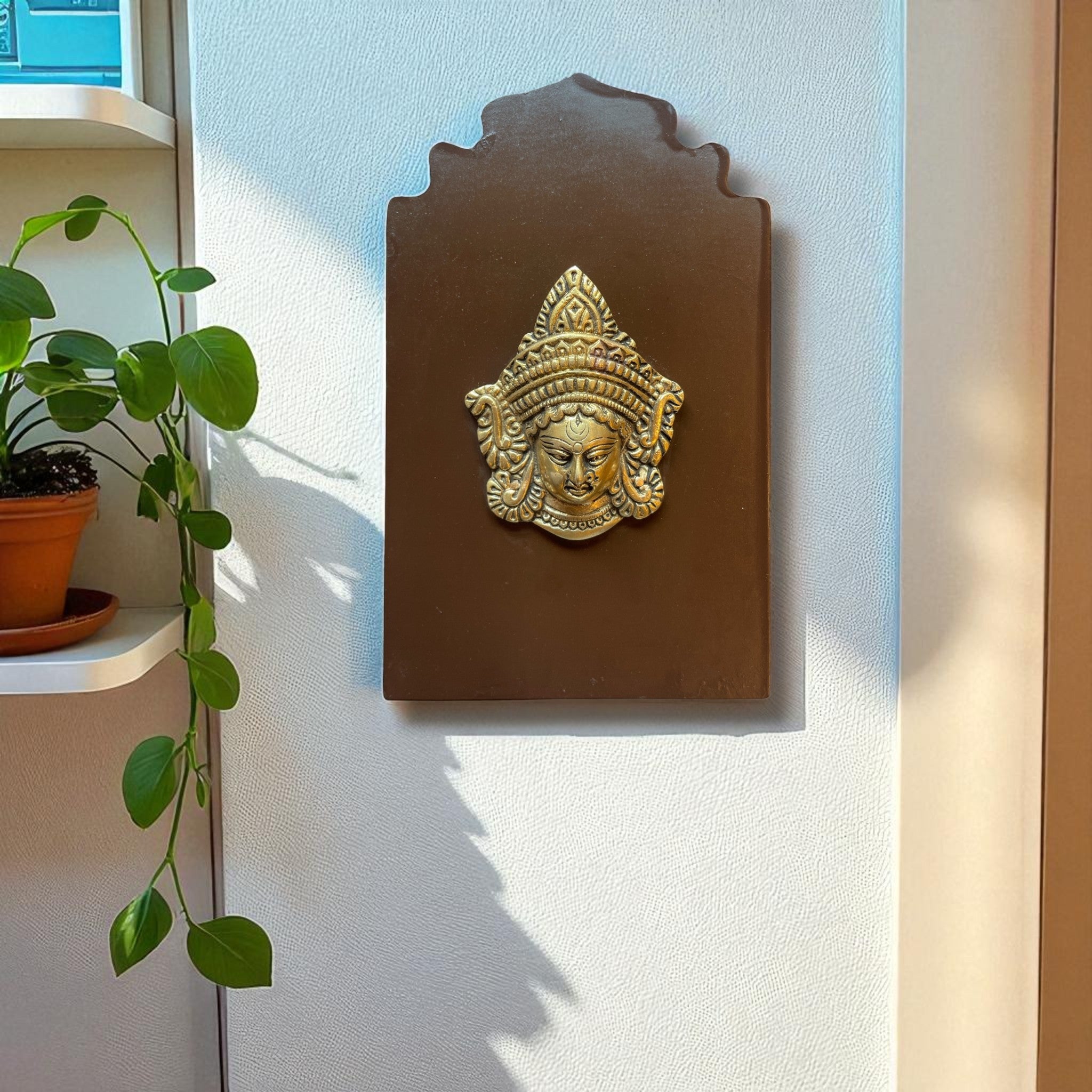 Brass Durga mask on wooden frame