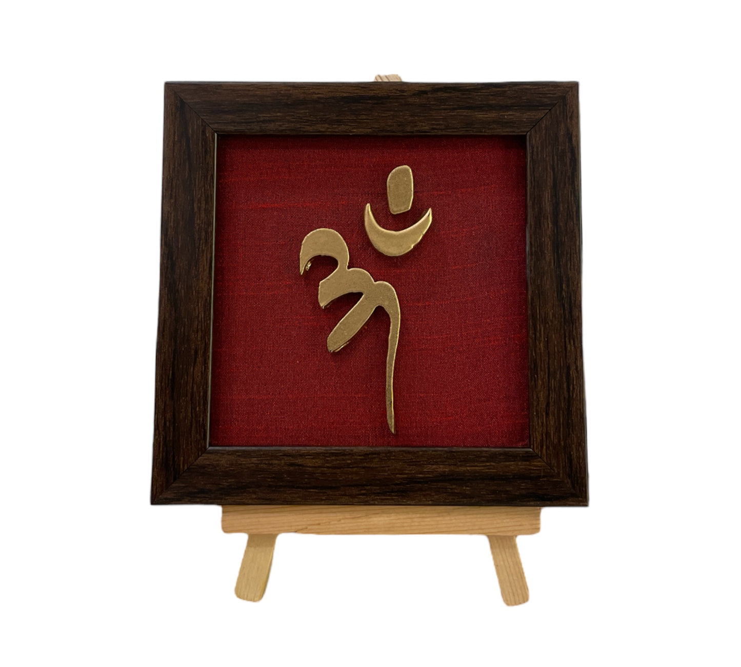 Vastu Aum 
Symbol in Metal on Wine red silk backdrop.