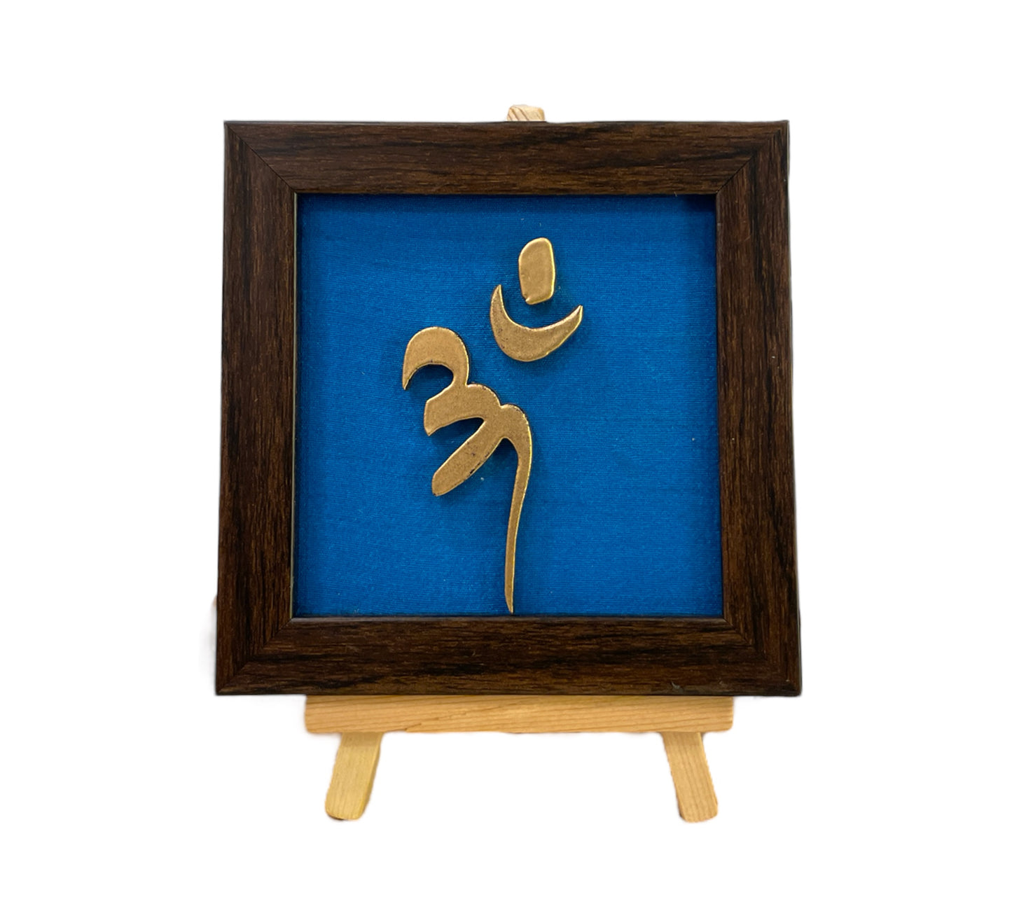 Vastu Aum 
Symbol in Metal on blue silk backdrop with a display stand.