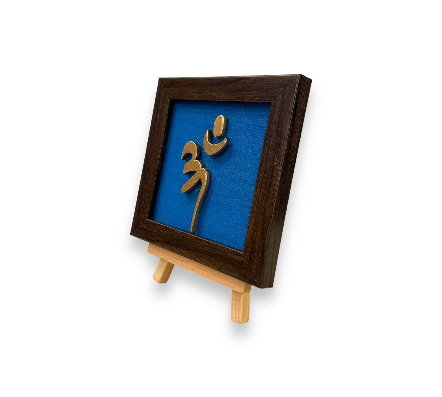 Vastu Aum 
Symbol in Metal on blue silk backdrop with a display stand.