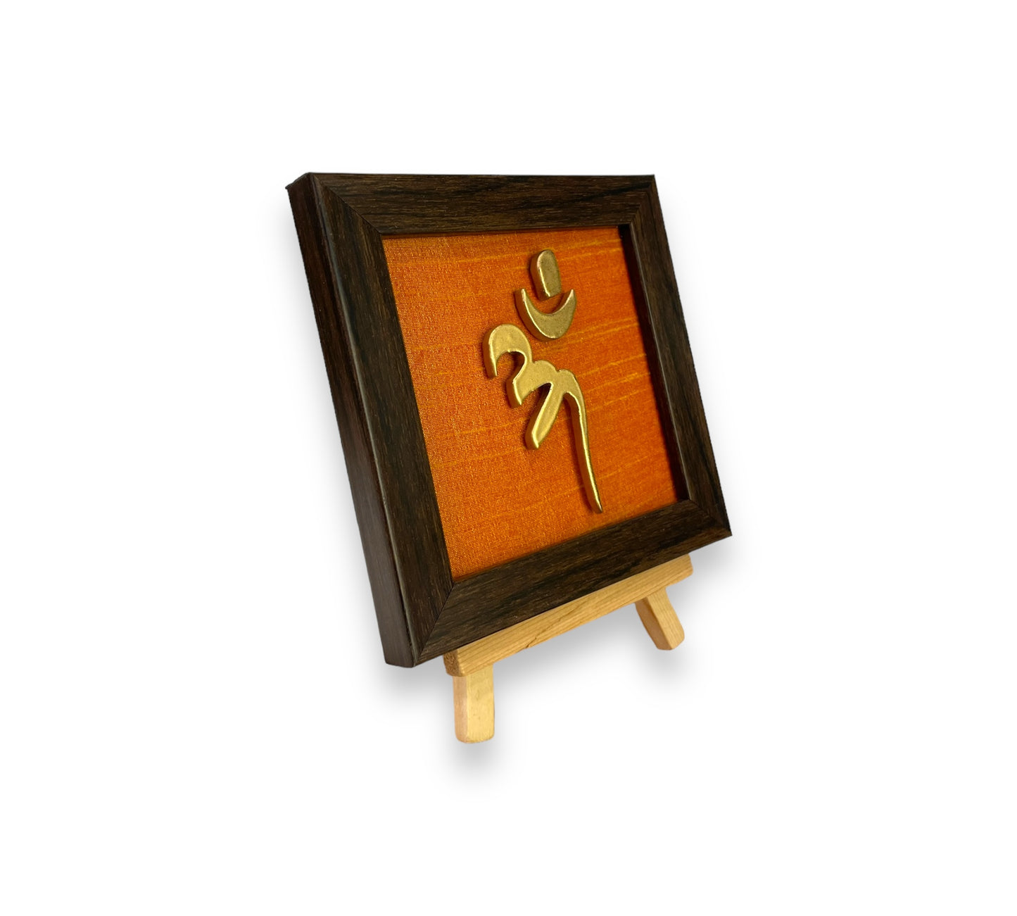 Vastu Aum Symbol in Metal on orange silk backdrop with a display stand.