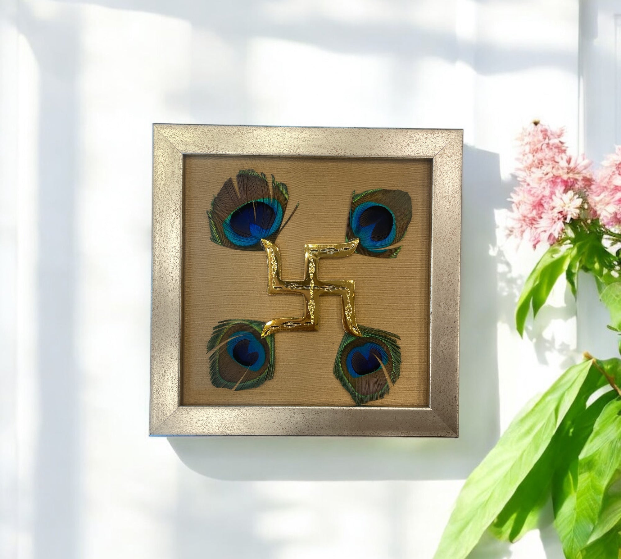 Brass swastik with Golden silk and peacock Feather in. Antique gold frame